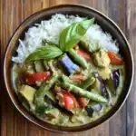 Creamy vegetable curry with rice, featuring eggplant, bell peppers, green beans, and fresh basil garnish | Queen Recipes.